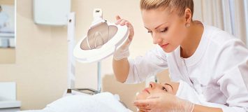 Esthetician examining a woman's skin.